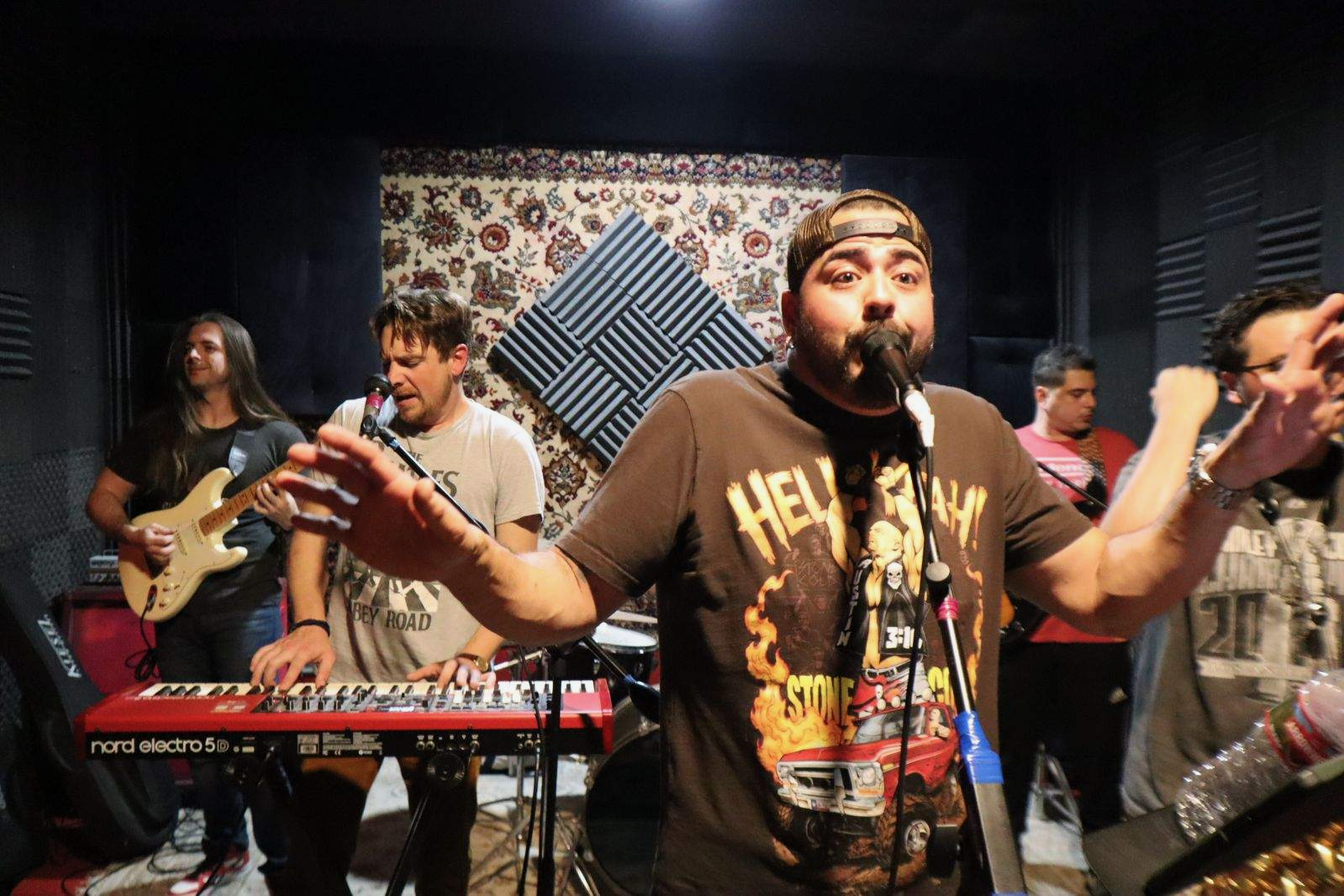 Clayton Munoz singing with his band, hands raised