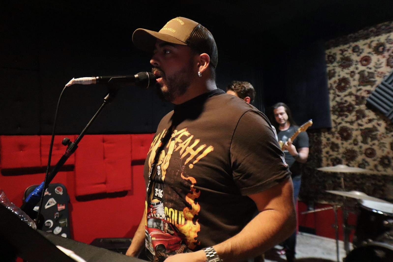 Clayton Munoz singing into a microphone during rehearsal